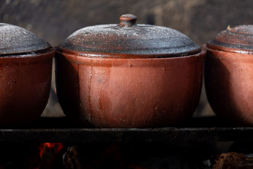 Clay pots warming over a wood fire.
